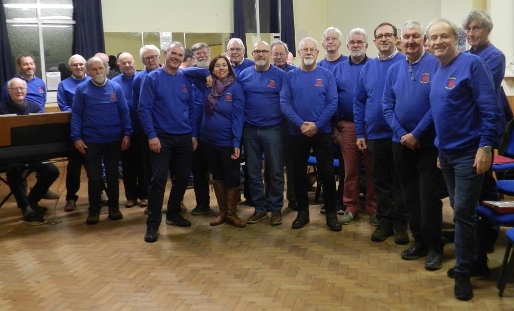 A group of older people stood together in a hall.