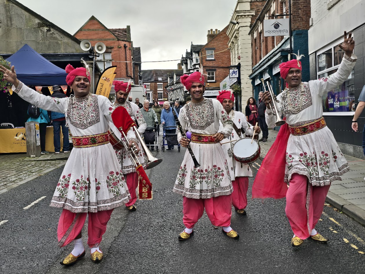 Three people dancing in street.